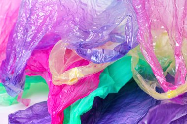 Abstract colorful background made from used disposable bags with handles. Waste management concept.