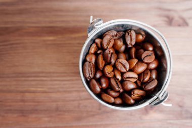 Bucket of roasted coffee beans, top view. Wholesale coffee supplies.