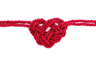 Heartbeat symbol made from braided red cord isolated on white background. Creative healthcare concept.