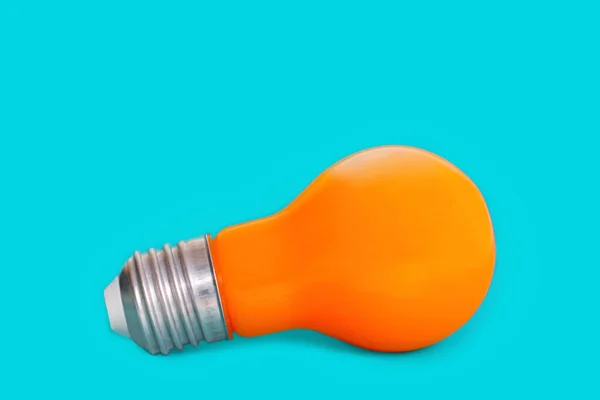 Orange Incandescent Light Bulb Isolated Blue Background — Zdjęcie stockowe