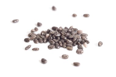 Pile of dry chia seeds isolated on white background, extreme macro, selective focus.