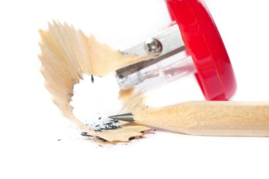 Sharpening a graphite pencil. Pencil tip, sharpener and shavings close-up.