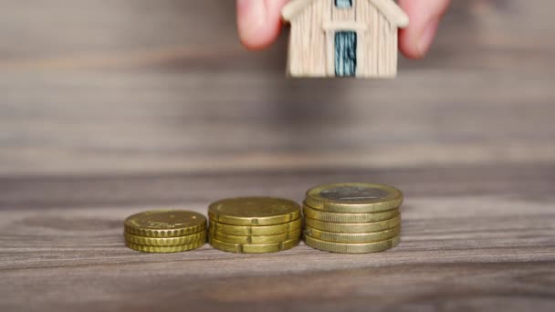 Hand Puts Small House Model Coins Stack Takes Back Wooden — Vídeos de Stock