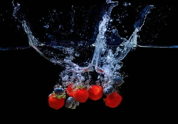 Mix Fresh Strawberries Blueberries Dropped Water Splashes Isolated Black Background — Stock Photo, Image