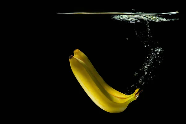 Twee Rijpe Bananen Drijvend Onder Water Geïsoleerd Zwarte Achtergrond — Stockfoto