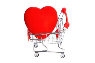 Büyük kırmızı kalp, beyaza izole edilmiş minyatür bir itme arabasına yerleştirilmiş. Romantik Sevgililer Günü konsepti.