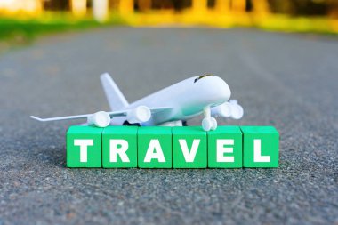 Uçak modeli ve kelime TRAVEL tahta alfabe bloklarından düzenlendi.