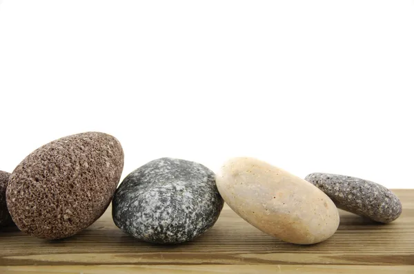 Piedras en un tablero de madera — Foto de Stock