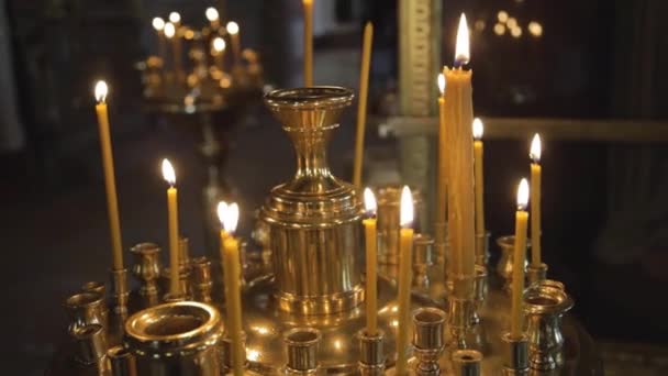 Церковные свечи горят в православной церкви — стоковое видео