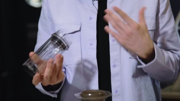 Barista robi kawę w kawiarni. Wlewanie gotowanej wody z czajnika w naczyniu z kawą uziemioną. — Wideo stockowe