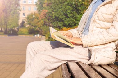 Park yerinde kitap okuyan bir kadın. Sonbahar havası.