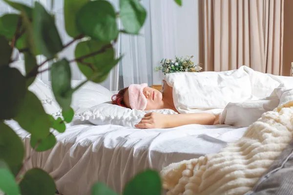 Junge Frau schläft mit Maske im Bett. — Stockfoto