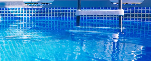 Banner. Escalera blanca de plástico en piscina prefabricada. Imagen De Stock