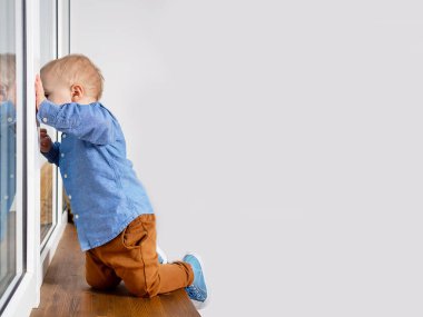 Pencerenin pervazında tehlikeli oynayan çocuk.