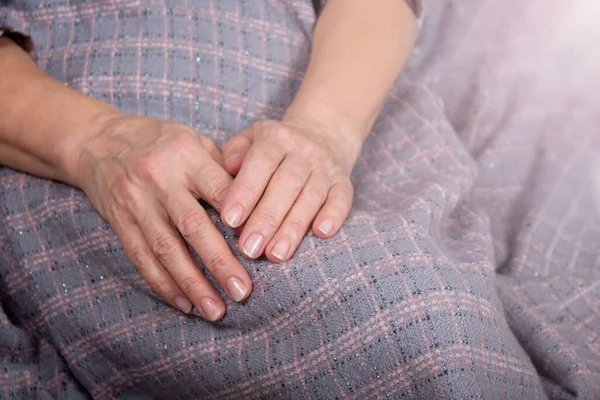 Las viejas manos de las mujeres descansan sobre el yeso. — Foto de Stock