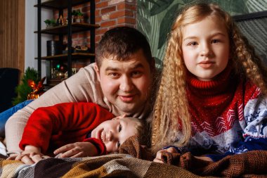 Baba oğul ve kız yatakta yatıyor.. 