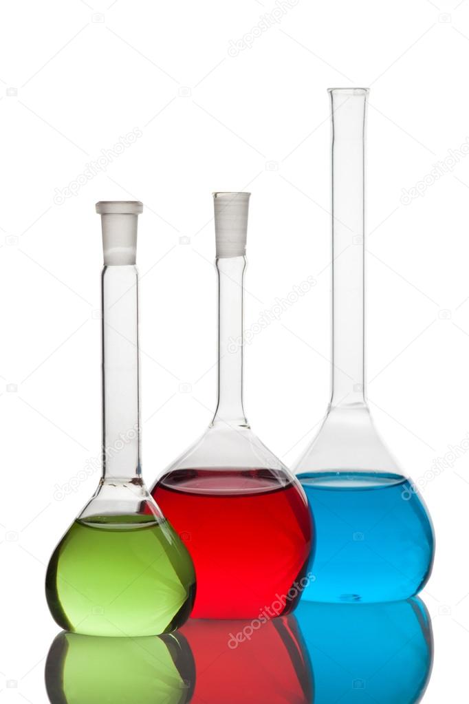 Set of laboratory glassware filled with multicolored liquids.