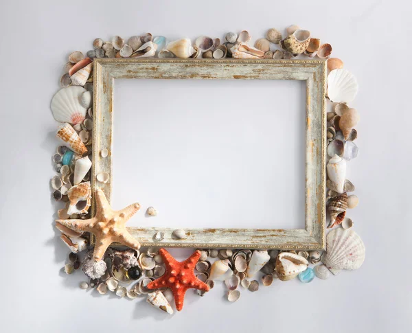Shabby picture frame with blank space inside and shells, on whit — Stock Photo, Image