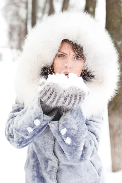 Vinterkvinne blåser snø – stockfoto