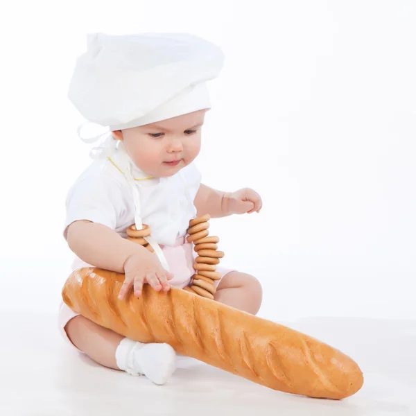 Baker baby girl with loaf and bagels — Stock Photo, Image