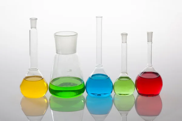 Laboratorieartiklar av glas med vätskor i olika färger — Stockfoto