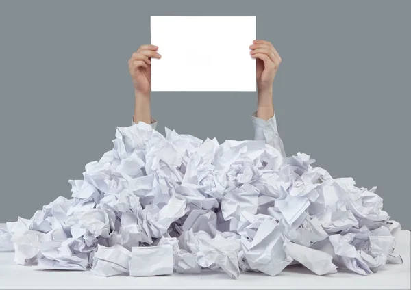 Hands with empty paper reaches out from big heap of crumpled papers — Stock Photo, Image