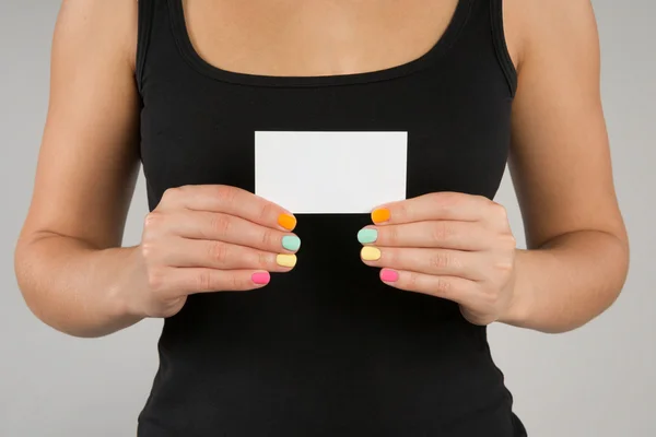 Menina com manicure brilhante mantém cartão de visita — Fotografia de Stock