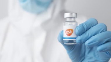 GSK ilaç şişesi ya da şişesi sağlık çalışanı ya da bilim adamı tarafından plastik eldivenlerle gösterildi, Ekim 2021, San Francisco, ABD.