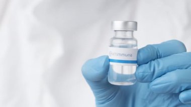 Sağlık çalışanı veya bilim adamı tarafından plastik eldivenlerle sunulan ilaç şişesi veya şişesi, Ekim 2021, San Francisco, ABD.