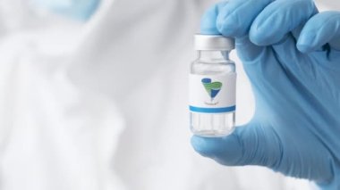 Sinopharm tüpü ya da ilaç şişesi sağlık çalışanı ya da bilim adamı tarafından plastik eldivenlerle gösterildi, Ekim 2021, San Francisco, ABD 