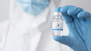 Sağlık çalışanı veya bilim adamı tarafından plastik eldivenlerle sunulan Sanofi şişesi veya şişesi, Ekim 2021, San Francisco, ABD 