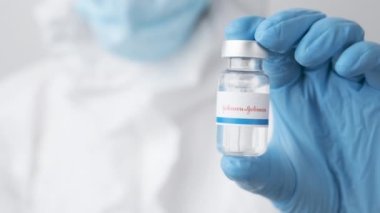 Johnson ve Johnson ilaç şişesi ya da şişesi sağlık çalışanı ya da bilim adamı tarafından plastik eldivenlerle gösterildi, Ekim 2021, San Francisco, ABD 