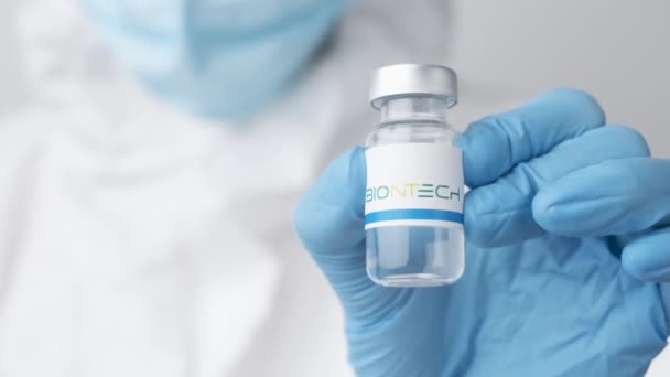 Vial o botella de Biontech con productos farmacéuticos demostrados por un trabajador de la salud o un científico en guantes de goma, octubre de 2021, San Francisco, EE.UU. — Vídeos de Stock
