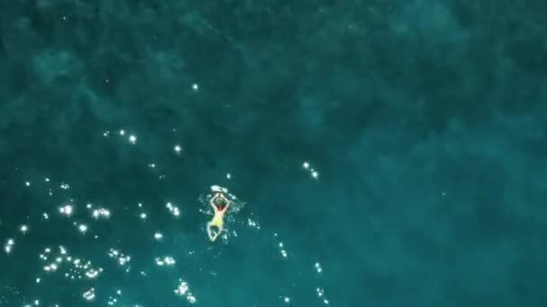 Вид над женщиной, купающейся в открытом море с прозрачной водой — стоковое видео