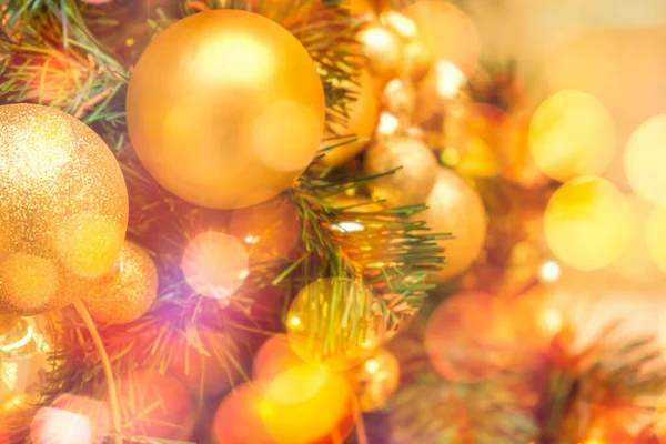 Прикрашені золотими різдвяними кульками на розмитому і блискучому світлому фоні — стокове фото