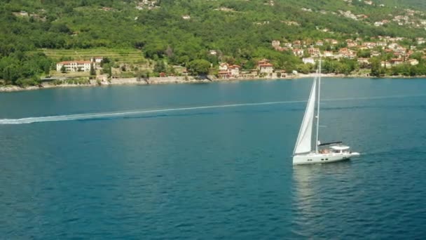 Vit segelbåt eller yacht segel på havet med blått vatten. Flygfoto över havet sidan av Adriatiska havet. — Stockvideo