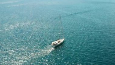 Beyaz yelkenli ya da mavi suyla denize açılan bir yat. Adriyatik deniz ve gemisinin hava manzarası