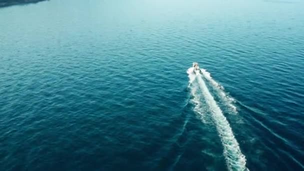 Drone vista de un barco blanco navegando en el mar azul. Un yate blanco moviéndose a alta velocidad. — Vídeos de Stock