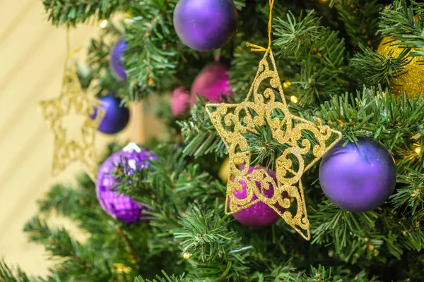 Luzes de estrela de ouro e guirlanda, decoração de brinquedos na árvore de Natal no fundo bokeh luz. — Fotografia de Stock