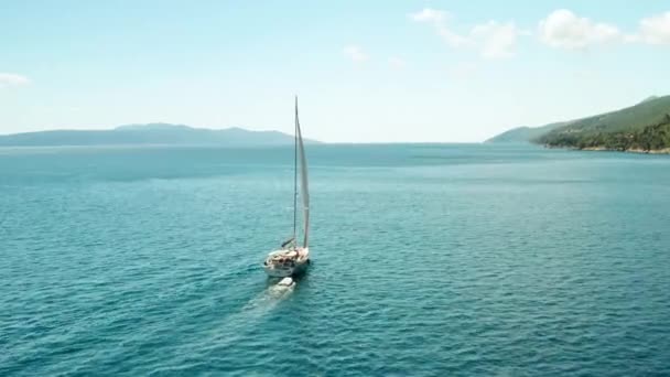 Velero blanco o yate navega en el mar con agua azul. Vista aérea de la orilla del mar Adriático. — Vídeos de Stock