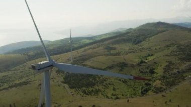 Dönen bir rüzgar türbininin üzerindeki bir dronun hava görüntüsü. Ekim 2021, Vratarusa, Hırvatistan 'da dağlarda ekolojik, yeşil, yenilenebilir enerji ve elektrik üretimi için rüzgar çiftliği