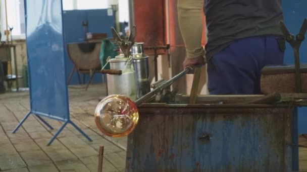 玻璃鼓风机在杆子上形成一个融化的玻璃气泡.玻璃制造工艺。玻璃瓶或花瓶的生产. — 图库视频影像