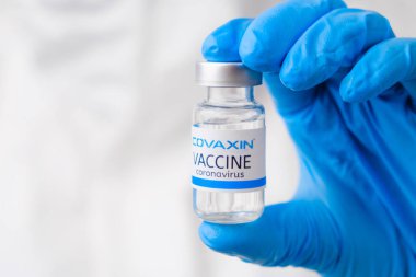 SARS-Cov-2, Coronavirus ya da Covid-19 'a karşı kovaxin aşısı lastik eldivenli sağlık çalışanı tarafından masaya kondu, Mart 2021, San Francisco, ABD