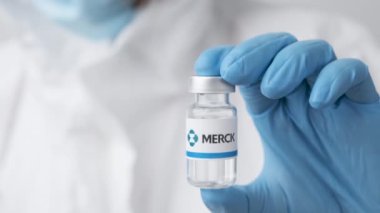 Merck şişesi ya da ilaç şişesi sağlık çalışanı ya da bilim adamı tarafından plastik eldivenlerle gösterildi, Ekim 2021, San Francisco, ABD 