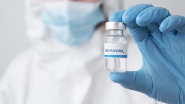 Novavax şişesi ya da şişesi sağlık çalışanı ya da bilim adamı tarafından plastik eldivenlerle gösterilmiş, Ekim 2021, San Francisco, ABD 