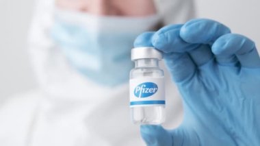 Pfizer şişesi ya da şişesi sağlık çalışanı ya da bilim adamı tarafından plastik eldivenlerle gösterilmiş, Ekim 2021, San Francisco, ABD 
