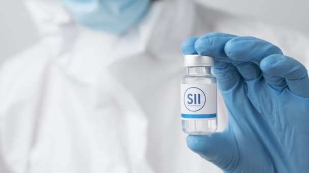Fiolka lub butelka Serum Institute of India SII z lekami wykazana przez pracownika służby zdrowia lub naukowca w gumowych rękawiczkach, październik 2021 r., San Francisco, USA — Wideo stockowe