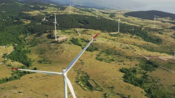 Nagranie z lotu drona nad turbinami wiatrowymi. Farma wiatrowa jest wysoko w górach do generowania zielonej energii. — Wideo stockowe