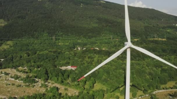 Voe sobre a hélice giratória de uma turbina eólica nas montanhas. Geração de energia verde — Vídeo de Stock