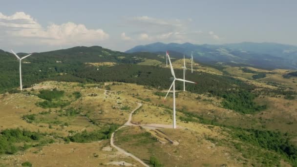Imágenes aéreas de molinos de viento o parque eólico en las montañas. Las turbinas eólicas generan electricidad verde y renovable que ayuda en los cambios climáticos. — Vídeos de Stock